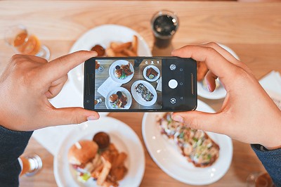 Une personne qui prend des plats en photo avec son portable